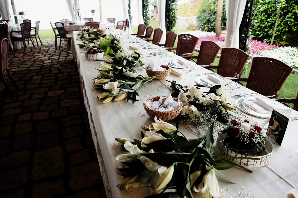 Una lunga tavola nuziale con fiori